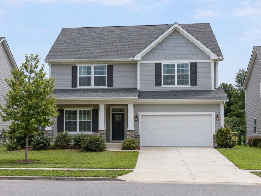 Two-story gray home with a plain shingle roof before solar panels were added